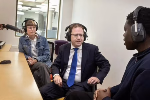 A group of people talking in a radio studio